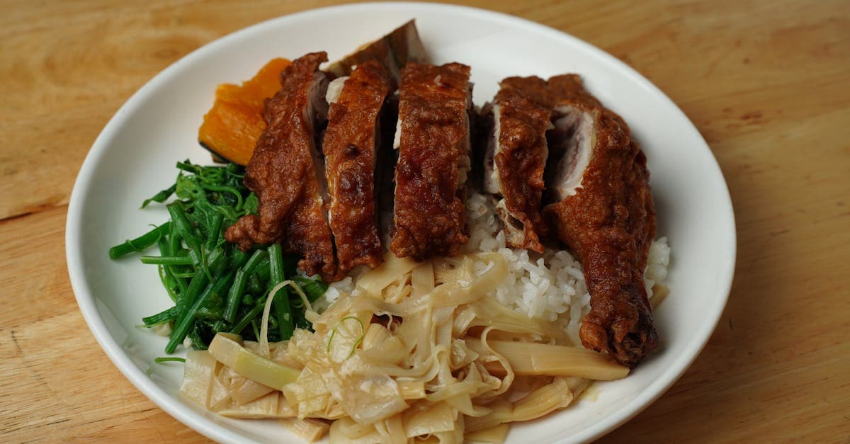 Sportif préparant un repas riche en protéines avec poulet et riz dans une cuisine
