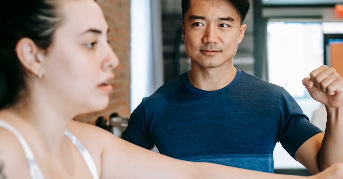 Coach sportif consultant une tablette avec son client dans une salle de musculation