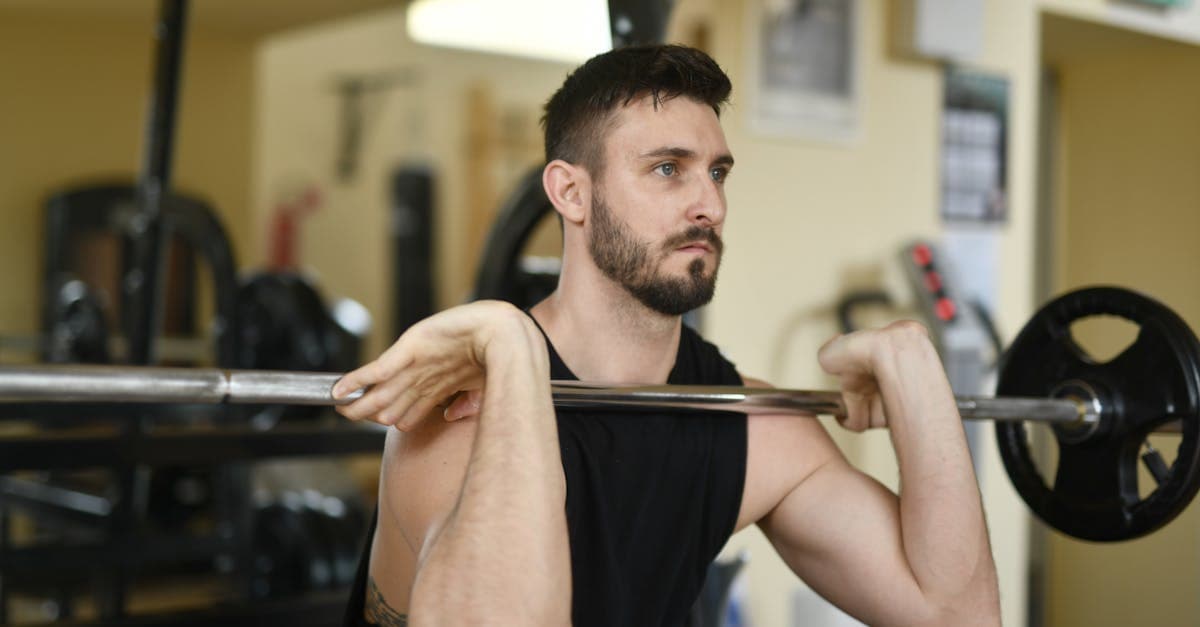 Homme réalisant un squat avec barre dans une salle de musculation moderne