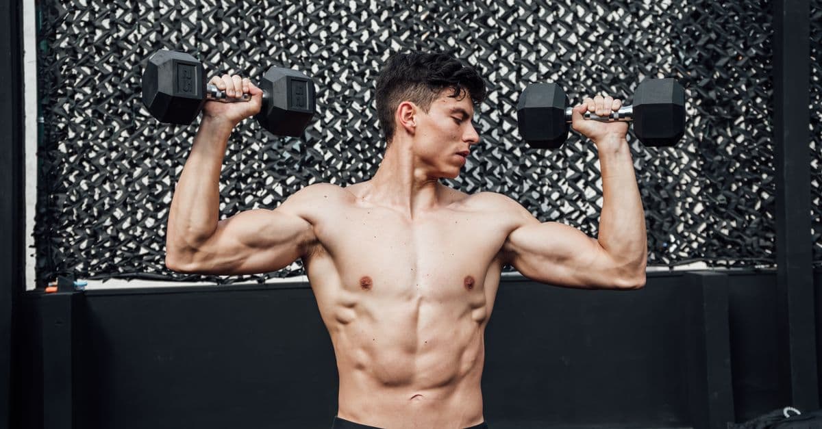 Sportif en salle de musculation planifiant son programme d entrainement avec haltères