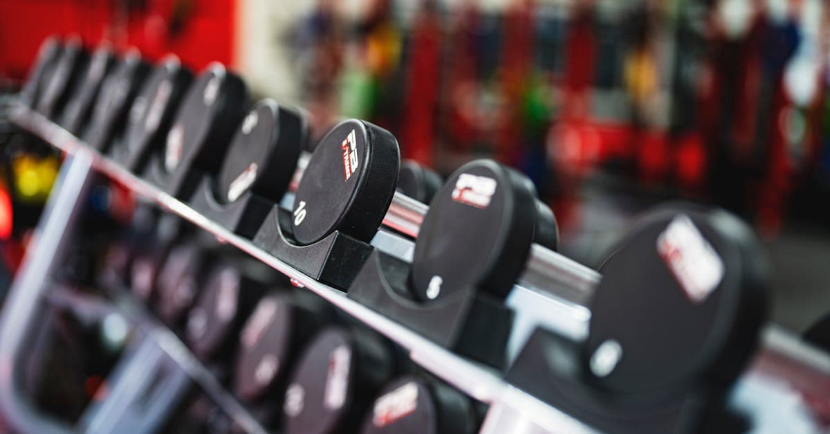 Sportif débutant effectuant un exercice de musculation avec haltères dans une salle de sport