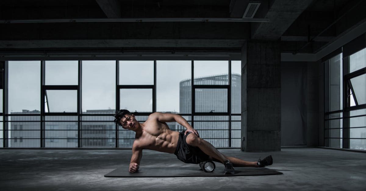 Sportif utilisant un foam roller pour la récupération musculaire après une séance de musculation